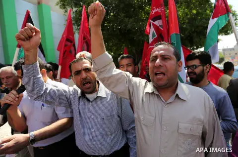 Palestinian supporters of the Democratic Front for the Liberation of Palestine (DFLP), hold banners during a protest to show solidarity with Palestinian prisoners on hunger strike in Israeli jails, in Gaza city on April...