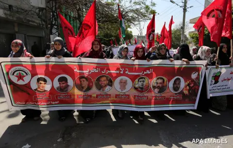 Palestinian supporters of the Democratic Front for the Liberation of Palestine (DFLP), hold banners during a protest to show solidarity with Palestinian prisoners on hunger strike in Israeli jails, in Gaza city on April...