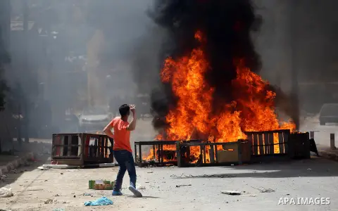 A Palestinian protester dodges teargas cannisters during clashes with Israeli forces in the West Bank village of Beita, southeast of Nablus city, after a protest took place following Friday prayers in solidarity with Pal...