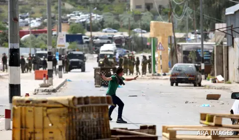 A Palestinian protester dodges teargas cannisters during clashes with Israeli forces in the West Bank village of Beita, southeast of Nablus city, after a protest took place following Friday prayers in solidarity with Pal...