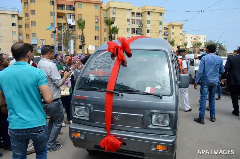 Egypians stand next to a mini-bus before Mona El Sayed, an Egyptian woman known in media as "girl cart" receives it which was funded by “Tahya Masr” (Long Live Egypt) fund in Cairo, Egypt, on April 22, 2017. Just days af...