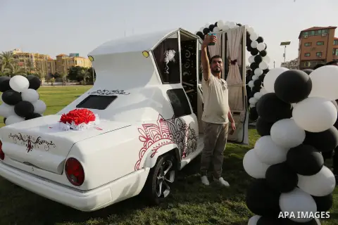 A Palestinian man taks a selfie inside a "Cinderella" vehicle in Gaza City on April 22, 2017. Made up of five different cars, it will be rented out for use at marriage ceremonies. Photo by Ashraf Amra