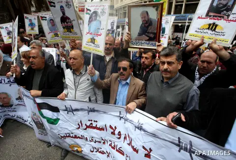 Palestinian protesters hold banners during a demonstration in solidarity with Palestinian prisoners on hunger strike in Israeli jails, in the West Bank of Nablus on April 23, 2017. Some 1,500 Palestinian prisoners have j...