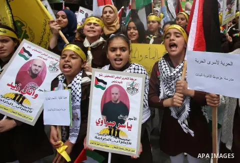 Palestinian protesters hold banners during a demonstration in solidarity with Palestinian prisoners on hunger strike in Israeli jails, in the West Bank of Nablus on April 23, 2017. Some 1,500 Palestinian prisoners have j...
