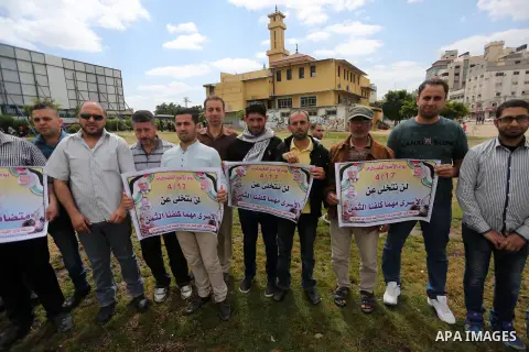 Palestinian protesters hold banners during a protest in solidarity with Palestinian prisoners on hunger strike in Israeli jails, in Gaza city on April 24, 2017. Some 1,500 Palestinian prisoners have joined the hunger str...