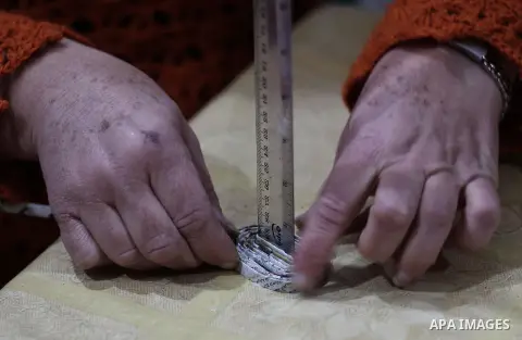 Evet Azzam, a Palestinian Christians woman, 53, makes a handmade clock from recycled newspapers at her house, in Gaza city on Feb. 10, 2017. Azzam uses an useless home materials to produce clocks, Nylon bags, chairs and...