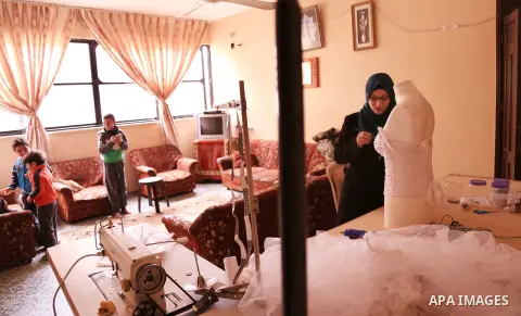 Manar Tafesh, 30, a Palestinian fashion designer works on knitting wedding dresses at her house with her husband to help him after he lost his work as tailor in the Palestinian territory occupied, in Gaza city on Feb. 14...