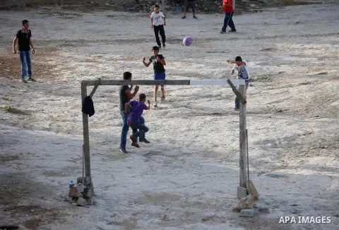 A picture taken on April 22, 2017 shows Palestinian boys play football, in the West Bank city of Nablus. Photo by Ayman Ameen
