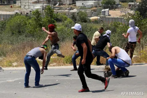 Palestinian protesters hurl stones towards Israeli security forces during clashes at a protest in support of Palestinian prisoners on hunger strike in Israeli jails, in the West Bank village of al-Naqoura, near Nablus on...
