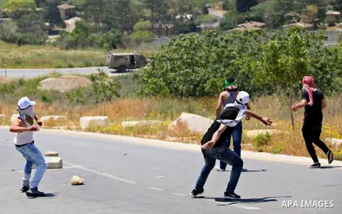 Palestinian protesters hurl stones towards Israeli security forces during clashes at a protest in support of Palestinian prisoners on hunger strike in Israeli jails, in the West Bank village of al-Naqoura, near Nablus on...