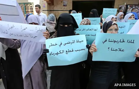 Palestinian women hold placards during a protest demanding end an Israeli blockade of the Gaza Strip, at Al-Shifa hospital in Gaza City on April 29, 2017. Photo by Ashraf Amra