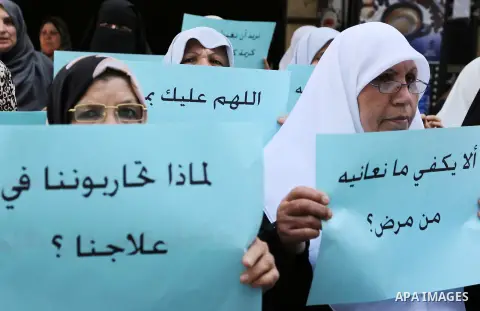 Palestinian women hold placards during a protest demanding end an Israeli blockade of the Gaza Strip, at Al-Shifa hospital in Gaza City on April 29, 2017. Photo by Ashraf Amra