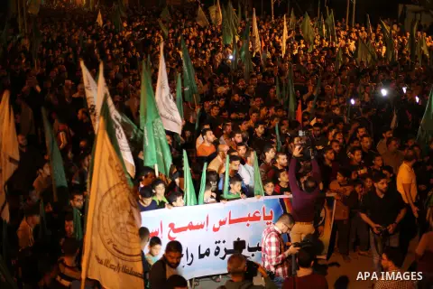 Supporters of the Palestinian Hamas movement hold banners during a protest against Palestinian President Mahmoud Abbas and Israeli blockade of the Gaza Strip, in Gaza city, on April 29, 2017. Photo by Mohammed Asad