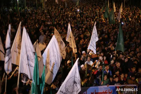 Supporters of the Palestinian Hamas movement hold banners during a protest against Palestinian President Mahmoud Abbas and Israeli blockade of the Gaza Strip, in Gaza city, on April 29, 2017. Photo by Mohammed Asad
