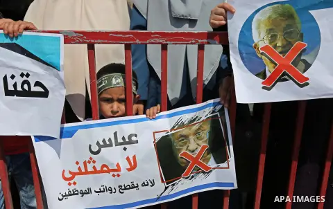 Palestinians hold a poster depicting Palestinian President Mahmoud Abbas during a protest against the blockade in Dair Al Balah, in the center of Gaza strip on May 2, 2017 demanding an end to the one-decade-old Israeli s...