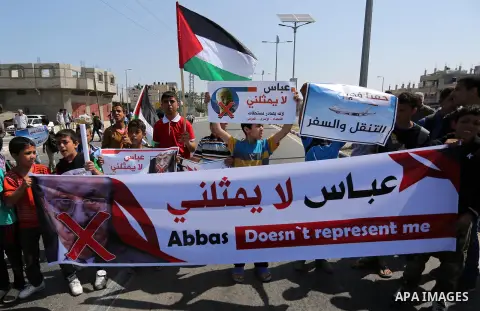Palestinians hold a poster depicting Palestinian President Mahmoud Abbas during a protest against the blockade in Dair Al Balah, in the center of Gaza strip on May 2, 2017 demanding an end to the one-decade-old Israeli s...