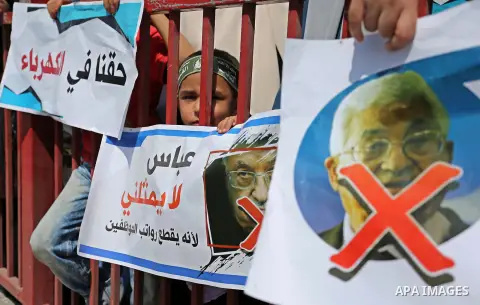 Palestinians hold a poster depicting Palestinian President Mahmoud Abbas during a protest against the blockade in Dair Al Balah, in the center of Gaza strip on May 2, 2017 demanding an end to the one-decade-old Israeli s...