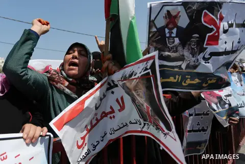 Palestinians hold a poster depicting Palestinian President Mahmoud Abbas during a protest against the blockade in Dair Al Balah, in the center of Gaza strip on May 2, 2017 demanding an end to the one-decade-old Israeli s...
