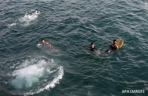 Palestinian youths swim as they enjoy in the Mediterranean Sea off the coast of Gaza City on May 5, 2017. Photo by Mohammed Asad