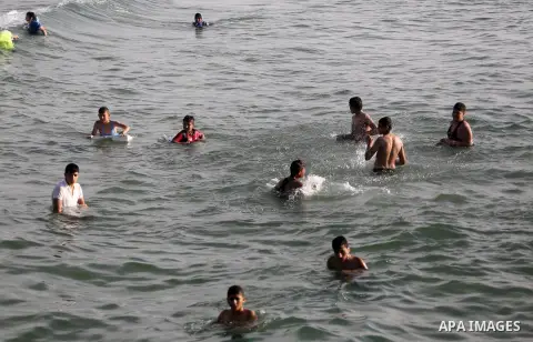 Palestinian youths swim as they enjoy in the Mediterranean Sea off the coast of Gaza City on May 5, 2017. Photo by Mohammed Asad