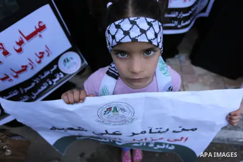 Palestinian supporters of Al-Ahrar movement hold banners during a protest against Palestinian President Mahmoud Abbas and Israeli blockade of the Gaza Strip, in Gaza city, on May 07, 2017. Photo by Ashraf Amra