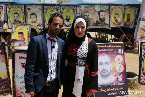 A Palestinian groom and his bride take part in their marriage ceremony at a sit-in in support of Palestinian hunger-striking prisoners held in Israeli jails, on May 8, 2017, in Gaza City. Photo by Ashraf Amra