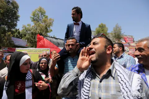 A Palestinian groom and his bride take part in their marriage ceremony at a sit-in in support of Palestinian hunger-striking prisoners held in Israeli jails, on May 8, 2017, in Gaza City. Photo by Ashraf Amra