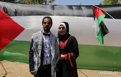 A Palestinian groom and his bride take part in their marriage ceremony at a sit-in in support of Palestinian hunger-striking prisoners held in Israeli jails, on May 8, 2017, in Gaza City. Photo by Ashraf Amra