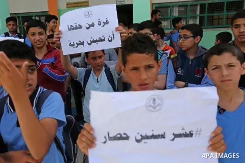 Palestinian students hold banners during a protest against Israeli blockade of the Gaza Strip, in Gaza city, on May 10, 2017. Photo by Ashraf Amra