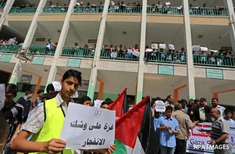 Palestinian students hold banners during a protest against Israeli blockade of the Gaza Strip, in Gaza city, on May 10, 2017. Photo by Ashraf Amra