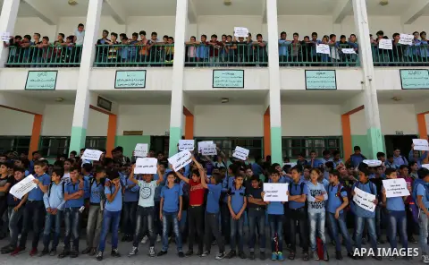Palestinian students hold banners during a protest against Israeli blockade of the Gaza Strip, in Gaza city, on May 10, 2017. Photo by Ashraf Amra