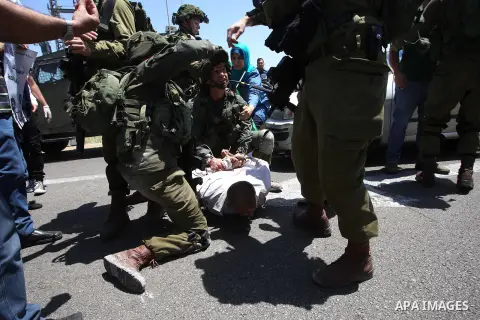 Israeli soldiers detain a Palestinian protester trying to block the main road between the West Bank city of Nablus and the Jewish settlement of Shavi Shamron during a demonstration in solidarity with Palestinian prisoner...