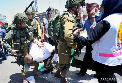 Israeli soldiers detain a Palestinian protester trying to block the main road between the West Bank city of Nablus and the Jewish settlement of Shavi Shamron during a demonstration in solidarity with Palestinian prisoner...