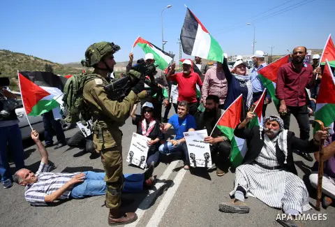 Israeli soldiers scuffle with Palestinian protesters trying to block the main road between the West Bank city of Nablus and the Jewish settlement of Shavi Shamron during a demonstration in solidarity with Palestinian pri...