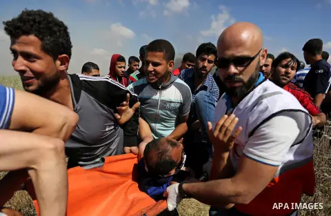 A Palestinian protester is evacuated after he was wounded during clashes with Israeli security forces following a protest against the blockade on Gaza Strip, near Nahal Oz crossing east of Gaza City on May 19, 2017. Phot...