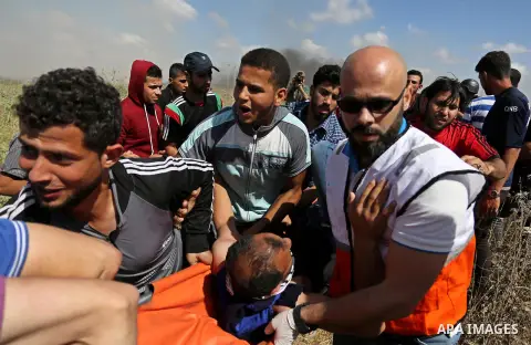 A Palestinian protester is evacuated after he was wounded during clashes with Israeli security forces following a protest against the blockade on Gaza Strip, near Nahal Oz crossing east of Gaza City on May 19, 2017. Phot...