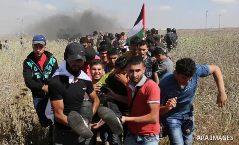 A Palestinian protester is evacuated after he was wounded during clashes with Israeli security forces following a protest against the blockade on Gaza Strip, near Nahal Oz crossing east of Gaza City on May 19, 2017. Phot...