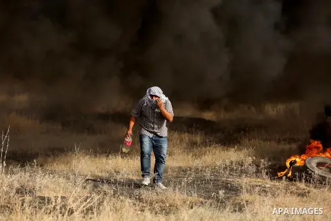 A Palestinian protester burns tires during clashes with Israeli security forces following a protest against the blockade on Gaza Strip, near the border fence east of Gaza City on May 22, 2017. Photo by Ashraf Amra