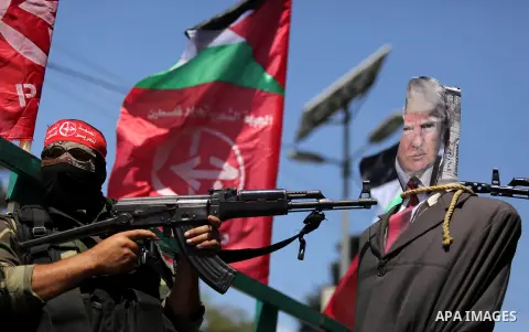 Palestinian militants from the Popular Front for the Liberation of Palestine (PFLP) aim their weapons at an effigy depicting U.S. President Donald Trump, in Gaza City May 23, 2017. Photo by Ashraf Amra