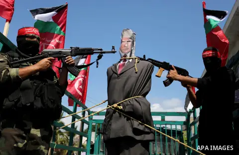 Palestinian militants from the Popular Front for the Liberation of Palestine (PFLP) aim their weapons at an effigy depicting U.S. President Donald Trump, in Gaza City May 23, 2017. Photo by Ashraf Amra