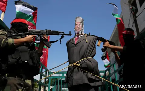 Palestinian militants from the Popular Front for the Liberation of Palestine (PFLP) aim their weapons at an effigy depicting U.S. President Donald Trump, in Gaza City May 23, 2017. Photo by Ashraf Amra
