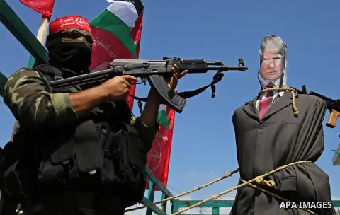Palestinian militants from the Popular Front for the Liberation of Palestine (PFLP) aim their weapons at an effigy depicting U.S. President Donald Trump, in Gaza City May 23, 2017. Photo by Ashraf Amra