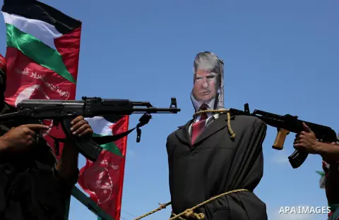 Palestinian militants from the Popular Front for the Liberation of Palestine (PFLP) aim their weapons at an effigy depicting U.S. President Donald Trump, in Gaza City May 23, 2017. Photo by Ashraf Amra