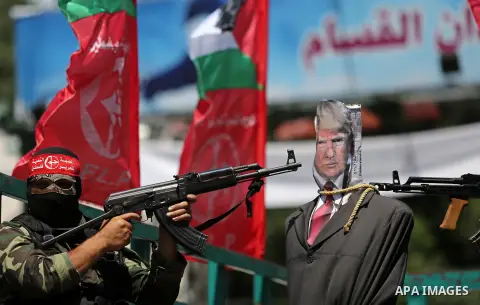 Palestinian militants from the Popular Front for the Liberation of Palestine (PFLP) aim their weapons at an effigy depicting U.S. President Donald Trump, in Gaza City May 23, 2017. Photo by Ashraf Amra