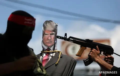 Palestinian militants from the Popular Front for the Liberation of Palestine (PFLP) aim their weapons at an effigy depicting U.S. President Donald Trump, in Gaza City May 23, 2017. Photo by Ashraf Amra