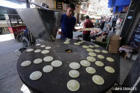 A Palestinian vendor prepares traditional pancakes known as ''Qatayef'' on the holy month of Ramadan at market in Gaza city on May 27, 2017. Ramadan is sacred to Muslims because it is during that month that tradition say...