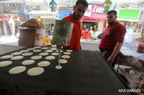 A Palestinian vendor prepares traditional pancakes known as ''Qatayef'' on the holy month of Ramadan at market in Gaza city on May 27, 2017. Ramadan is sacred to Muslims because it is during that month that tradition say...