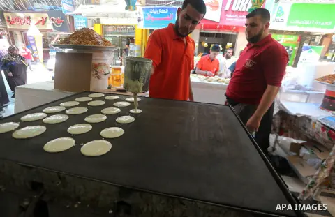 A Palestinian vendor prepares traditional pancakes known as ''Qatayef'' on the holy month of Ramadan at market in Gaza city on May 27, 2017. Ramadan is sacred to Muslims because it is during that month that tradition say...