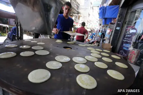 A Palestinian vendor prepares traditional pancakes known as ''Qatayef'' on the holy month of Ramadan at market in Gaza city on May 27, 2017. Ramadan is sacred to Muslims because it is during that month that tradition say...