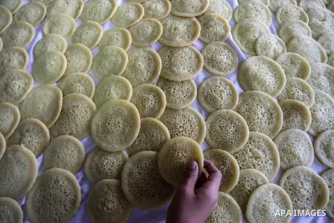 A Palestinian vendor prepares traditional pancakes known as ''Qatayef'' on the holy month of Ramadan at market in Gaza city on May 27, 2017. Ramadan is sacred to Muslims because it is during that month that tradition say...